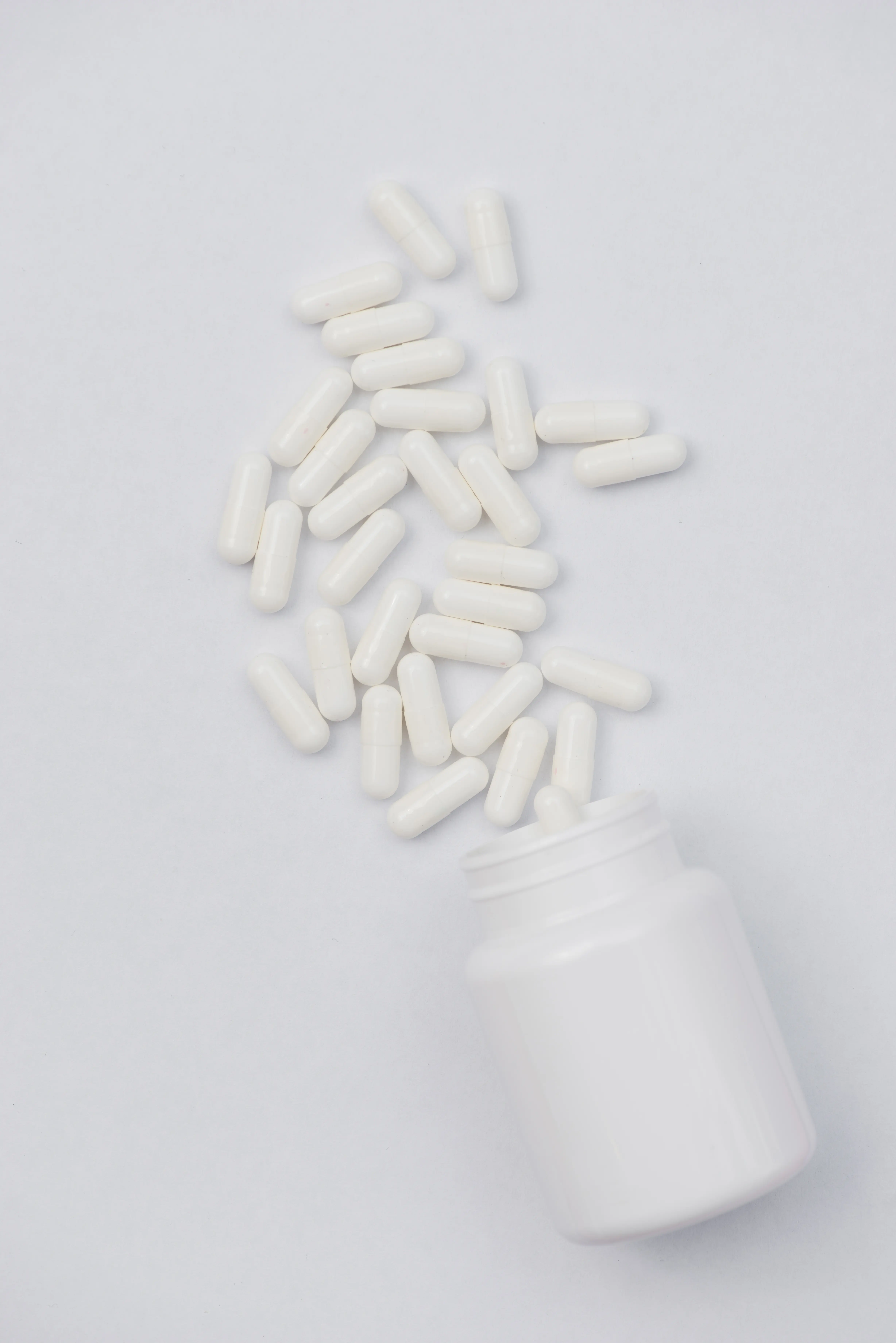 White capsules spilling from a bottle